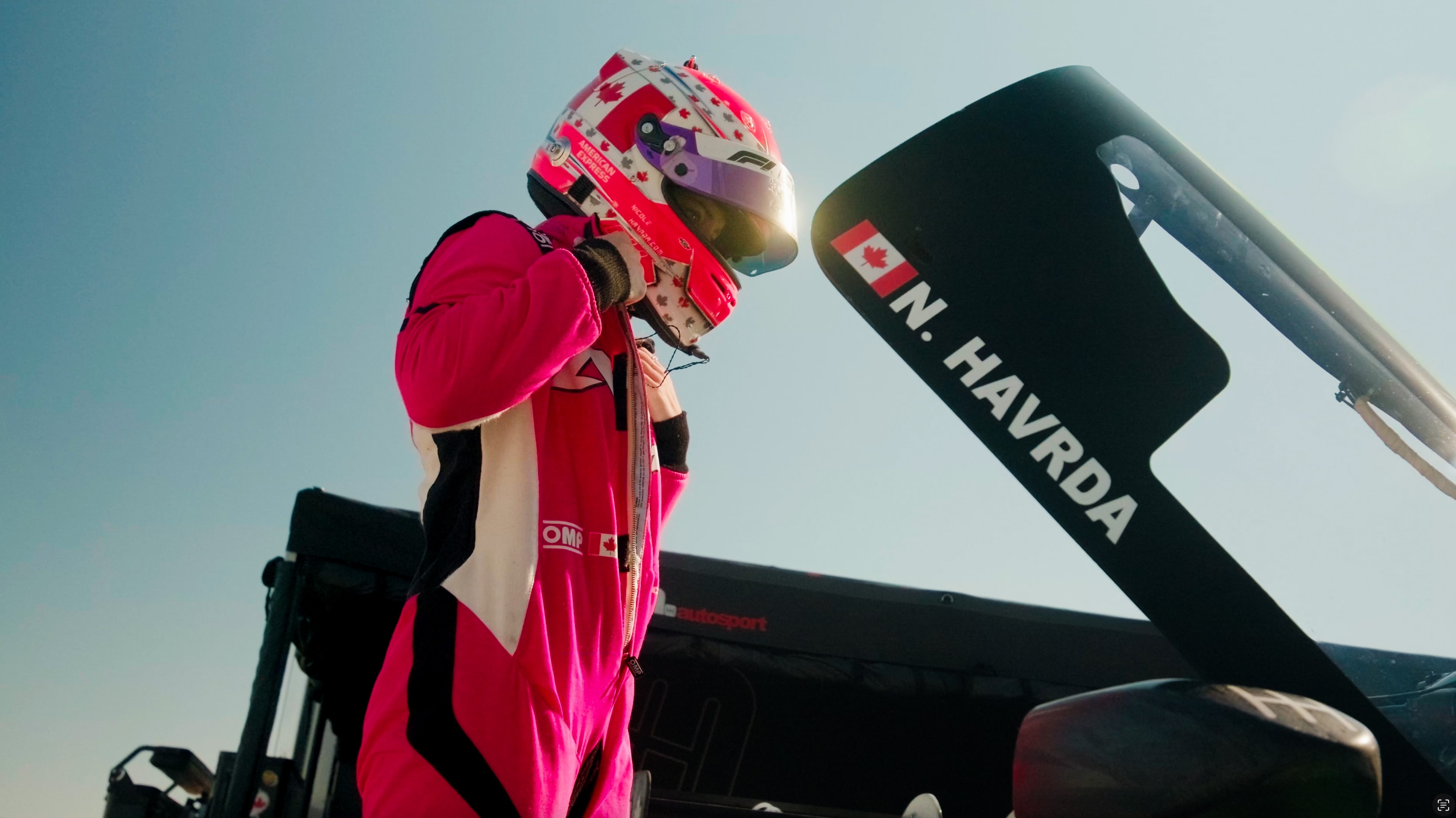 Race driver beside a car during a pit lane photo shoot